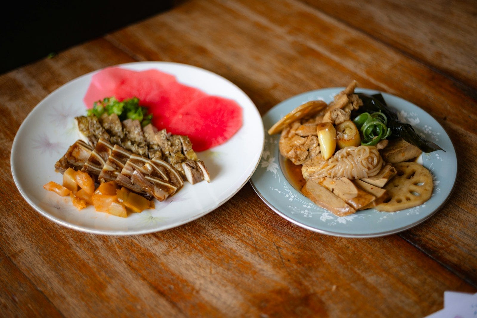 Two plates with a variety of prepared food.